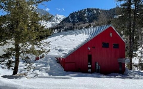 Exterior view of red Marble Fire Station building covered in snow