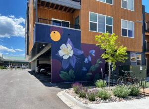 Mural painting of columbine flowers on side of Sopris Lofts building