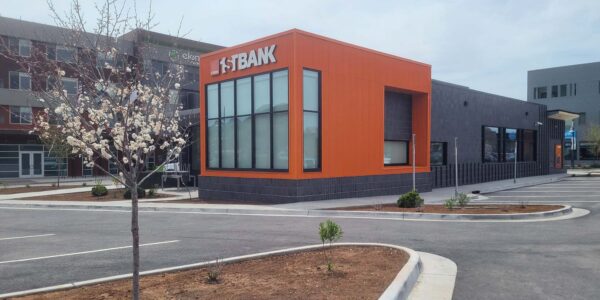 Photo of newly constructed 1st Bank building in Basalt, CO showcasing custom brick work and distinctive orange siding as seen from the parking lot