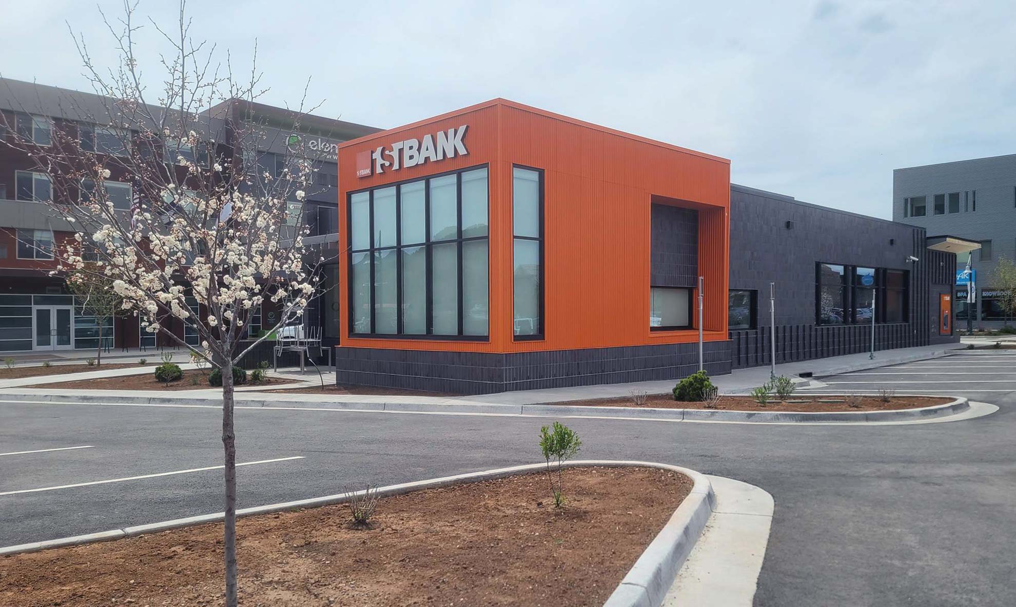 Photo of newly constructed 1st Bank building in Basalt, CO showcasing custom brick work and distinctive orange siding as seen from the parking lot